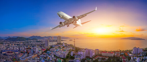 Nha Trang panoramic view from above jet airplane take off on the beach and city mouth river mountains in the distance early in morning dawn in the sky