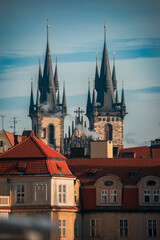 Obraz premium Exploring the striking spires of Prague's historic buildings under a clear sky in the afternoon light