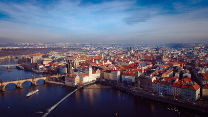 Obraz premium Aerial view of Prague showcasing its historic architecture and the Vltava River under a clear blue sky during daylight