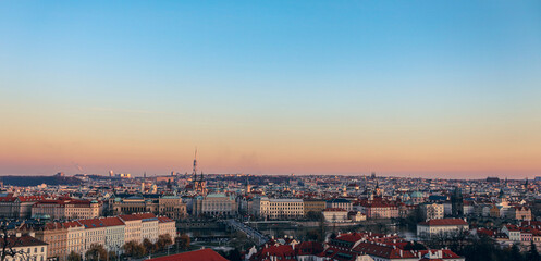 A stunning panoramic view of Prague's skyline at sunset, showcasing historic architecture and vibrant rooftops across the city
