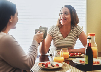 Happy, lesbian couple and breakfast with coffee, cheers or healthy meal together for morning or bonding at home. Young, female people or LGBTQ with smile for warm beverage, snack or eating at house