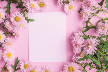 Obraz premium Asters pink background. Festive holiday greeting card for Birthday, Woman or Mothers Day, blank copy paper and a greeting card. View from above.