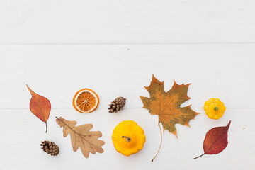 Autumn holiday frame composition with pattern made of leaf, punpkins, dried orange, pine cone on...
