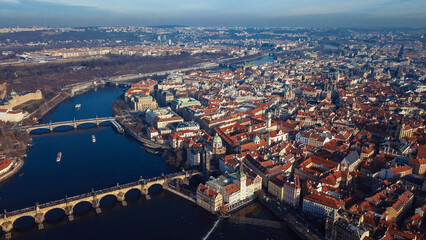 Obraz premium Aerial view of Prague showcasing the cityscape bridges and Vltava River during sunny daylight hours