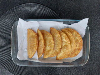 fried pastry in a baking tray on a black background