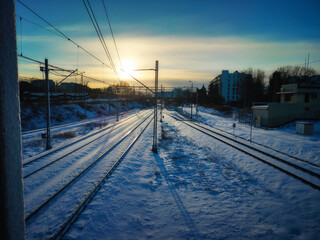Winter Morning Rail Tracks in Snowy Landscape at Sunrise