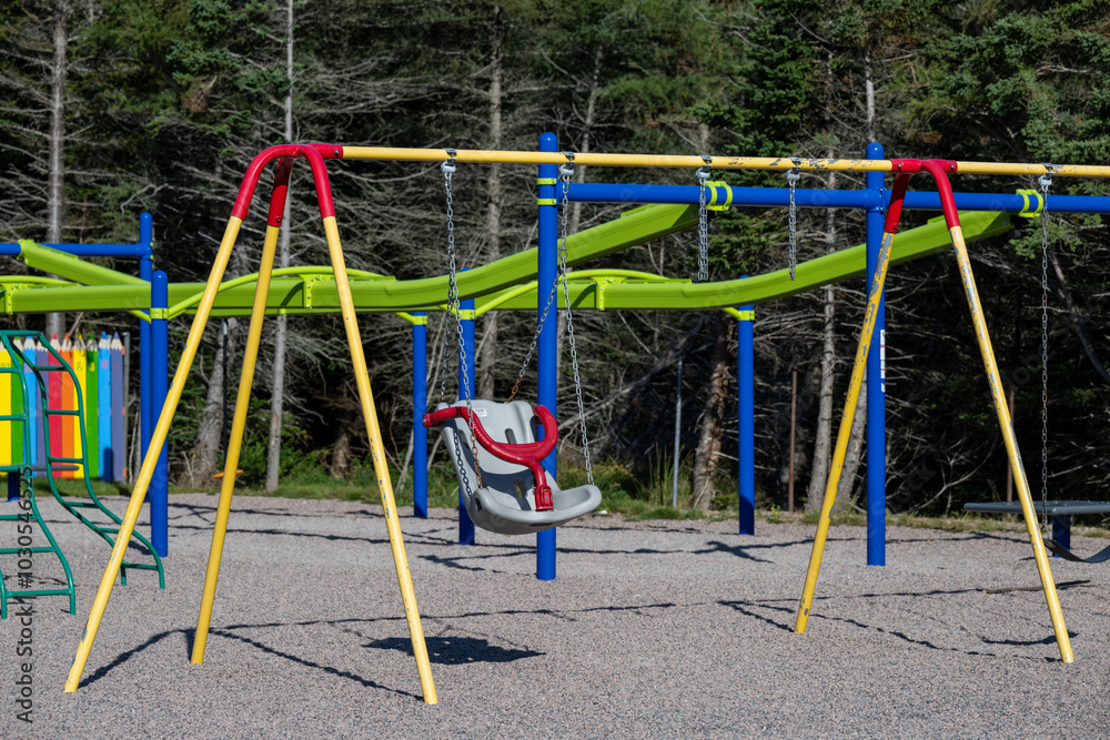 Wall mural a children's playground with a colorful metal swing set, a children's swing chair and a monkey climb