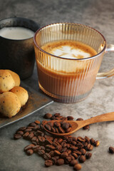 Hot latte, coffee beans and fresh milk with baked desserts