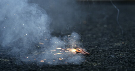 Firecrackers on the ground emitting sparks in slow-motion at 800 fps, capturing the moment of...