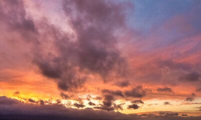 A beautiful sky tinted by the sun leaving vibrant shades of gold, pink, blue and multicolored. Clouds in the twilight evening and morning sky. Cloudy sky background in the evening, and during the day.