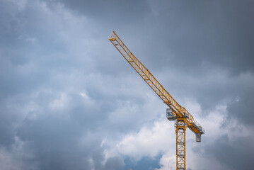 grey cloudy sky background and yellow tower crane