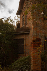 an old, abandoned red brick building overgrown with bushes