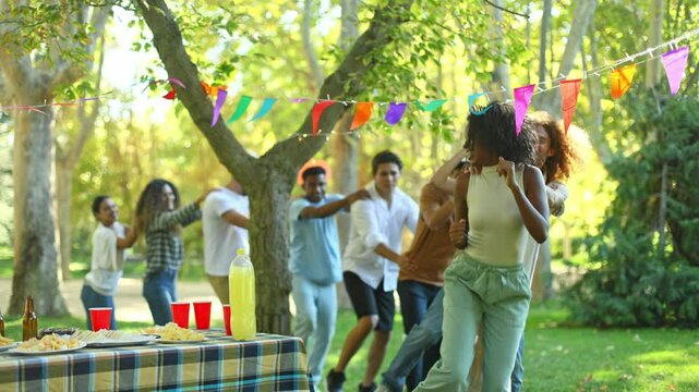 Friends enjoying conga line at outdoor party