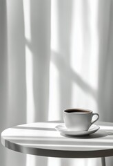 A white coffee cup sits on a round table with soft shadows and sunlight streaming through curtains