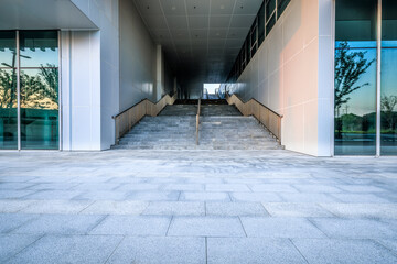 Empty brick floor with staircase passage and commercial building background