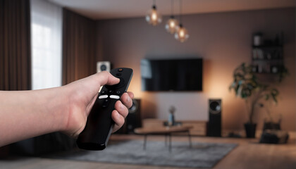 Hand holding a remote control, adjusting smart home devices in a modern living room. Concept of home automation, controlling lights, curtains, and smart speakers