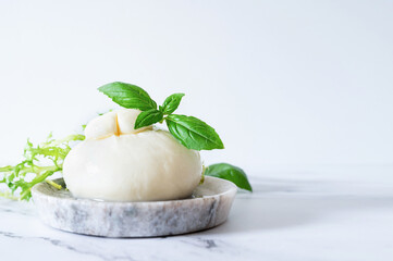 Burrata, the creamy Italian mozzarella cheese, is served with fresh basil.