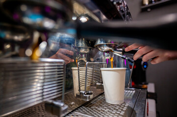 Skilled barista operating an espresso machine, filling a white cup with fresh coffee in a cozy café ambiance