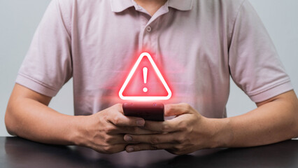Mobile Security Alert, A Man Using a Smartphone with a Scam Warning Symbol to Highlight the Growing Threat of Mobile Fraud and Cyber Scams in the Digital Age.