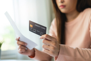 Debt and finance loan concept, Stressed woman holding a mock-up credit card and has an anxious facial expression.