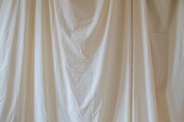 A white curtain hangs in the background