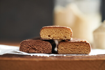 Three vegetarian protein chocolate bars with whey protein powder in the background