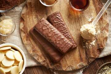 Protein chocolate bars with ingredients - whey protein powder, honey, peanut and cocoa butter, raw cacao and maple syrup