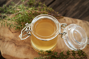 A jar of thyme syrup on a table