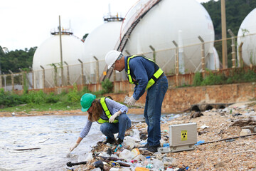 A senior couple of environmental engineers are hard at work outdoors, analyzing and collecting wastewater samples in an industrial area.