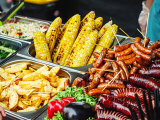 Grilled Street Food Feast: Fresh and Healthy Barbecue with Corn, Sausages, and Salad at a Vibrant Summer Event