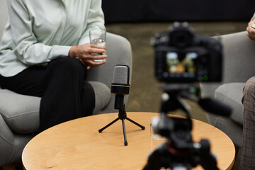 A middle-aged female journalist engages in a thoughtful interview with a man in a relaxed...