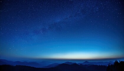 Fototapeta premium Expansive Night Sky Over Mountainous Horizon with Thousands of Stars Illuminating the Deep Blue Twilight, Capturing the Serene Transition from Dusk to Dawn in a Vast and Tranquil Wilderness