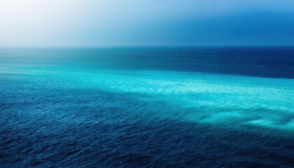 Obraz premium Vivid Ocean Gradient. Turquoise and Deep Blue Sea Waters Converge under a Clear Horizon. Perfect for Coastal Tranquility Concepts, Nature Scenes, or Oceanic Travel Destinations