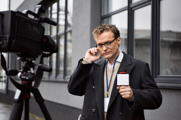 A dedicated journalist holds a microphone, preparing for an important live report during a rainy...