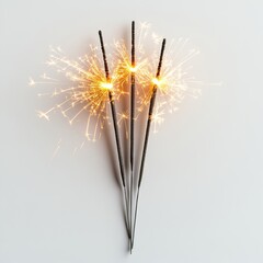 Fototapeta premium Three burning sparklers lit up against white background in diagonal arrangement