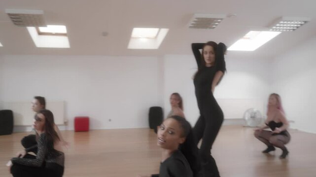A group of women practices a High Heels routine in a dance studio. The students rehearse expressive dance moves as part of their hobby. Adult dance classes provide a creative and empowering experience