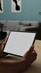 A person holding a tablet with a blank screen, sitting at a desk. Mockup for apps like note-taking, video calls, or browsing. Ideal for office or home usage