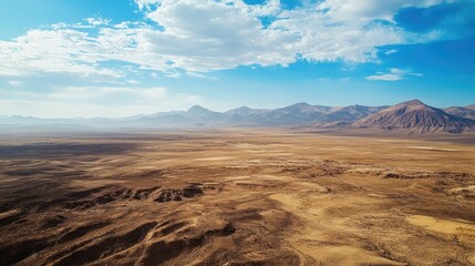Aerial view of the Atacama Desert with barren, sunlit plains and large open sky for copy