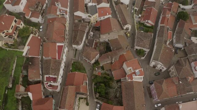 Drone shot of Monchique town's rooftops and narrow streets on an overcast day in Portugal.