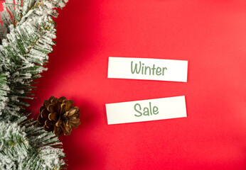 Red background with a wreath of pine needles and a sign that says Winter Sale © Алла Морозова