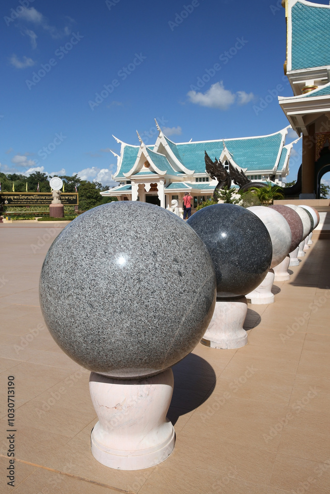 Wall mural Wat Pa Phu Kon: Buddhist temple, Na Yung (Udon district), Thailand. Religious traditional national Thai architecture. Beautiful landmark, architectural monumen, sight.  Round stones for contemplation