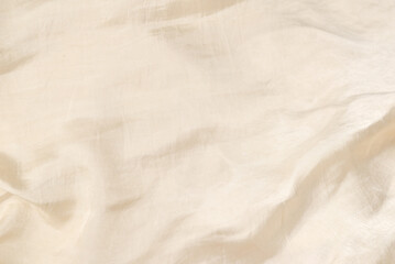 Soft smooth beige silk fabric background. Fabric texture.