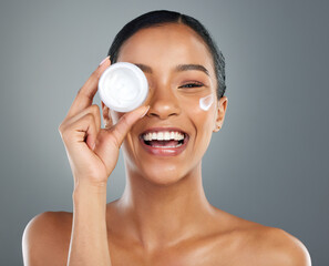 Woman, skin cream and container in studio portrait with smile, wellness and beauty by background. Girl, person and model with cosmetics, serum and moisturizer product for transformation in Colombia