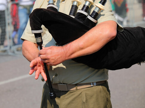 bagpipe player who quickly sets the notes to play and the melody during a parade through the city streets