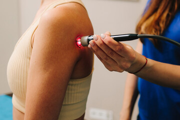 Laser therapy for chronic back pain. Woman is healing with red light to reduce pain, inflammation...