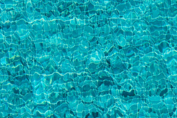 The Shimmering Turquoise Surface of a Tranquil Pool Reflecting Sunlight and Creating Mesmerizing Patterns