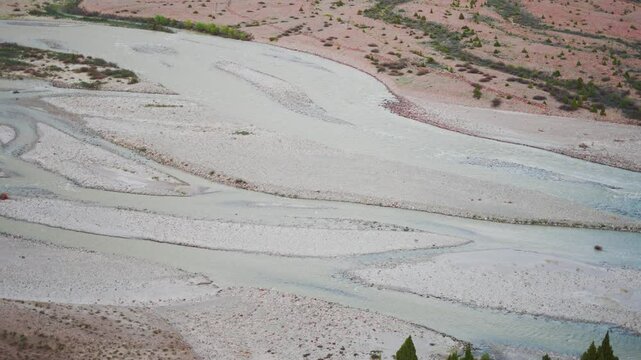 4K Closeup shot of river Bhaga flowing in the riverbed besides the mountain as seen from Jispa village in Lahaul and Spiti district, Himachal Pradesh, India. River flowing in the mountains background.