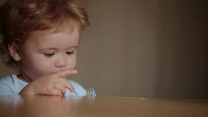Baby eats with a spoon. Child have a meal. Hungry little kid eating kids food. Baby porridge. Little baby eating healthy food. A Little baby eating her dinner. Funny curios kids facial expression.