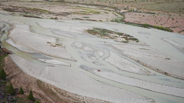 4K Closeup shot of river Bhaga flowing in the riverbed besides the mountain as seen from Jispa village in Lahaul and Spiti district, Himachal Pradesh, India. River flowing in the mountains background.