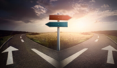 Split road and signpost with arrows showing two different courses, left and right directions for choice. Roadway fork junction, difficult decision concept